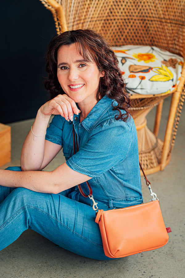 petit sac à main en cuir couleur pêche zippée. porté en bandoulière fait localement à Montréal
