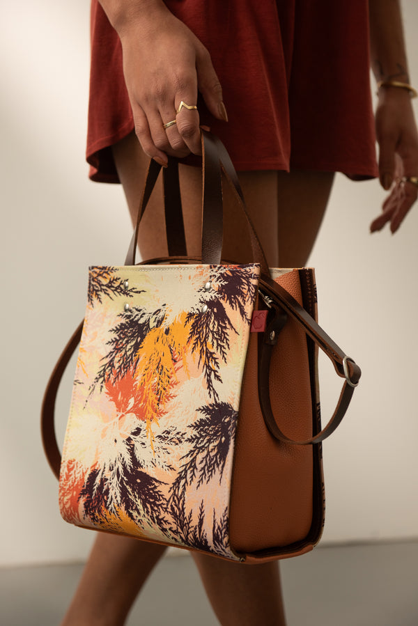 Sacoche en cuir rigide carré couleur peach fuzz et tissu imprimé orange. Fait localement au Canada.