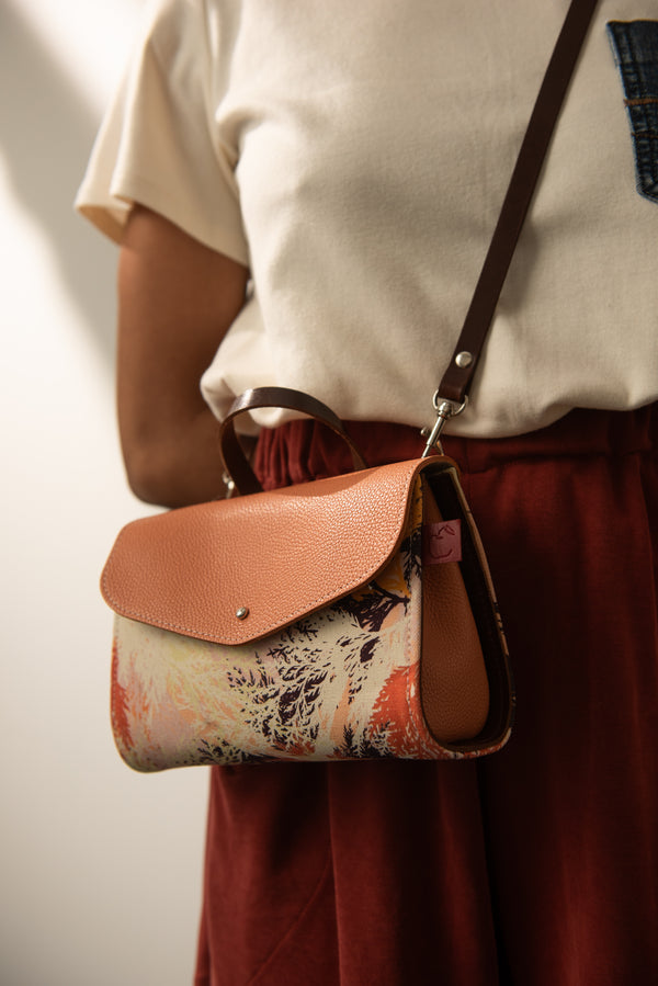 Sac à bandoulière fait à la main en cuir pêche et textile imprimé orange.