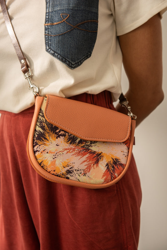 Sac à bandoulière pochette de taille en cuir peach fuzz et tissu imprimé orange et jaune. Fabriqué au Québec.