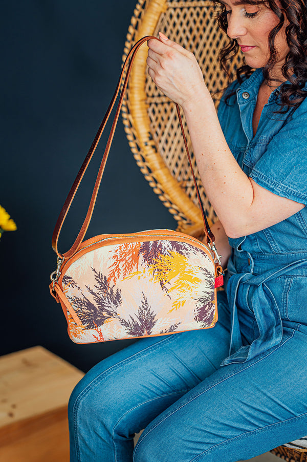 Sac à bandoulière orange pêche en cuir avec tissu imprimé branches de cèdre. Slow fashion fait à Montréal