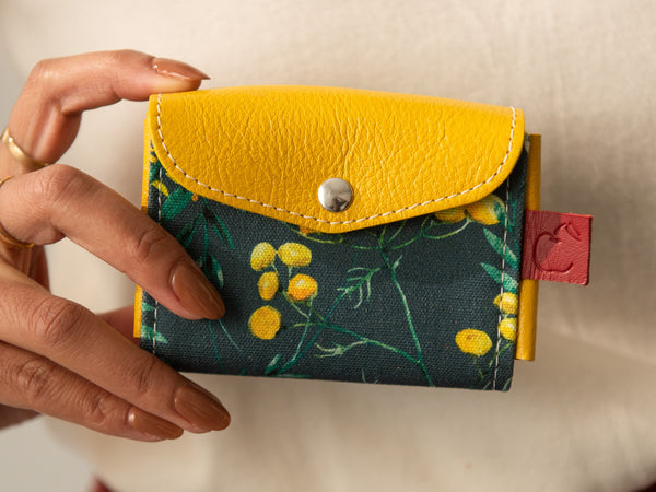 Mini portefeuille en cuir jaune soleil et toile fleurs sauvages bleu marin. Porte-cartes slow fashion fait au Canada.